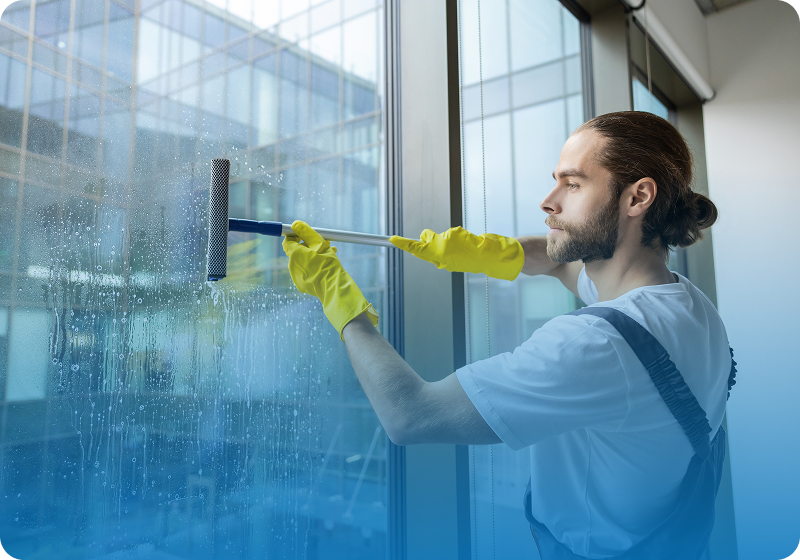 Man cleaning large window with squeegee.