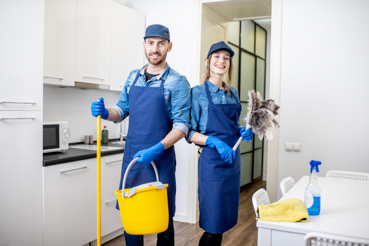 Cleaning team in a kitchen, smiling.